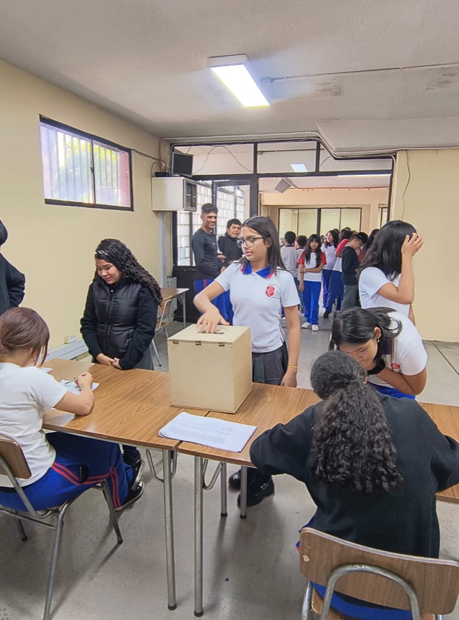 Estudiantes depositando su voto en la urna